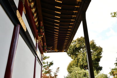 Low angle view of trees and building against sky