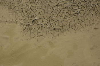 High angle view of sand by cracked field
