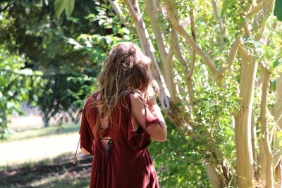 Rear view of woman standing near tree