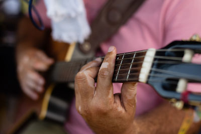 Detail of hands playing a guitar with nylon strings. professional musician.