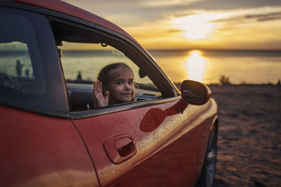 Portrait of woman in car during sunset