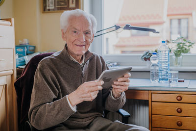 Portrait of young woman using mobile phone at home