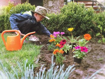 Boy planting flowers in yard