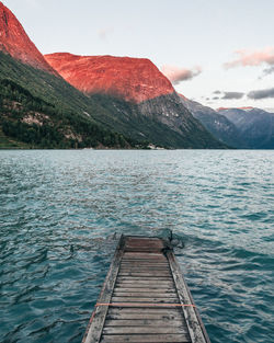 Stairs leading to fjord glacier water and a sunset over the mountain range