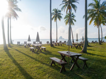 Chairs on table by sea against sky