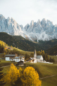 Houses by lake and mountains against sky