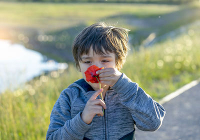 Close-up of boy smelling flower