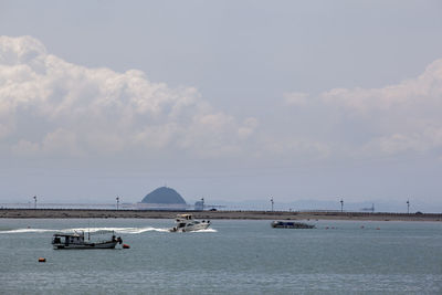 Boats on sea by daebudo island against sky