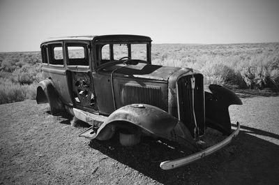 Abandoned truck on landscape against clear sky