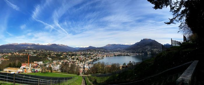 Panoramic view of townscape by mountains against sky