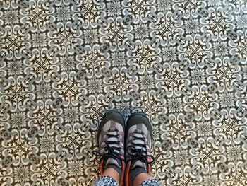 Low section of woman standing on tiled floor