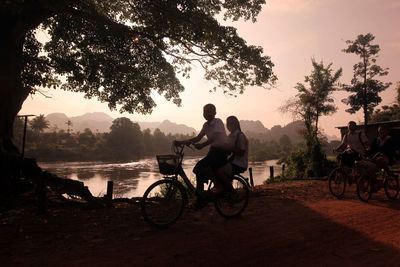 Girls riding bicycle on road by river