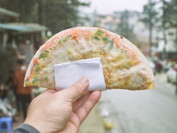 Close-up of hand holding vietnames pizza