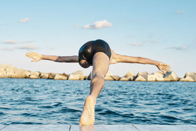 Amputee male diving into water on sunny day