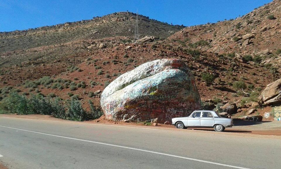 CAR ON ROAD AGAINST MOUNTAIN