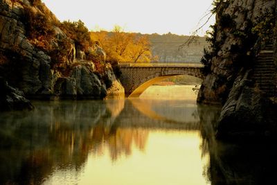 Footbridge over river against sky