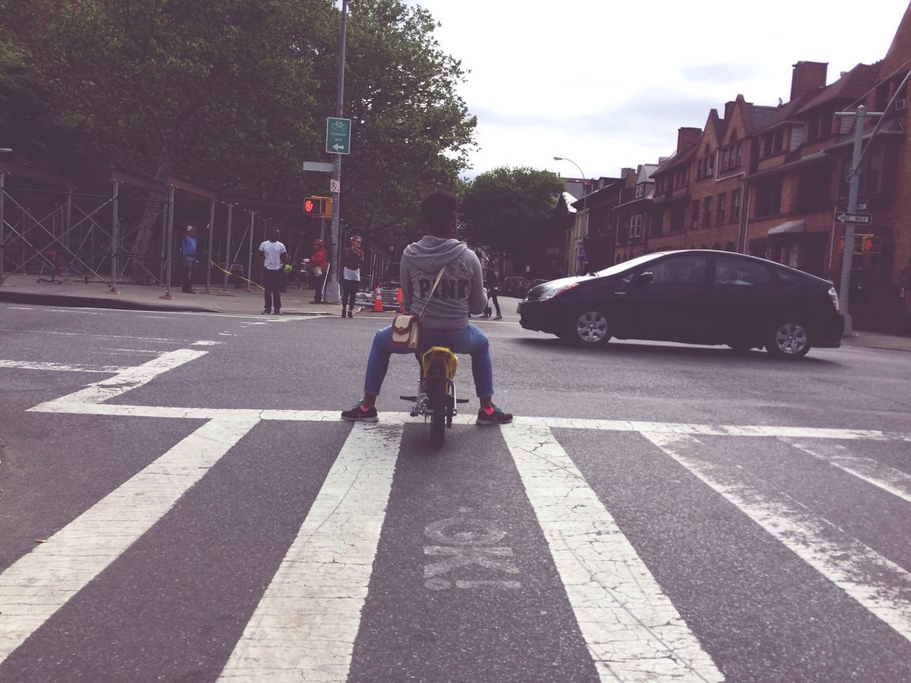 transportation, street, road, city, road marking, building exterior, lifestyles, mode of transport, car, land vehicle, city life, men, architecture, built structure, city street, walking, leisure activity, rear view