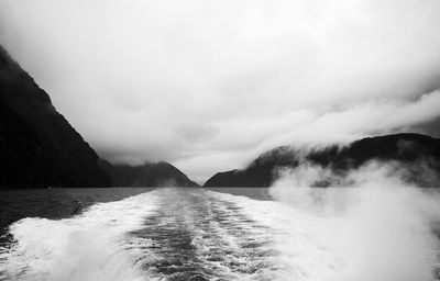 Scenic view of river and mountains against cloudy sky