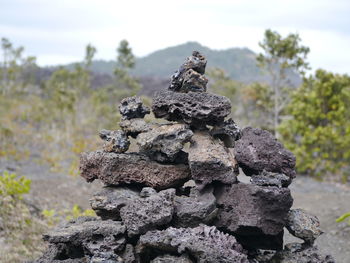 Close-up of stone stack on field against sky