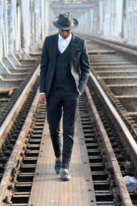 Full length of man walking on railroad tracks