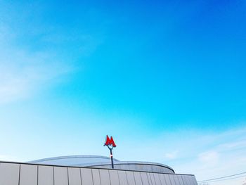 Low angle view of flag against blue sky