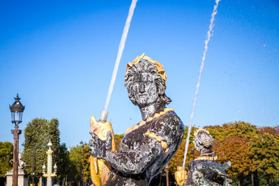 Low angle view of statue against clear blue sky