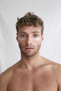 Portrait of shirtless man against white background