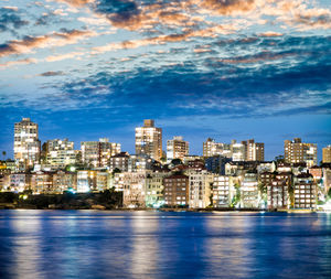 Illuminated buildings in city against sky at night