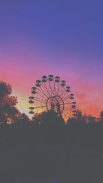 Low angle view of silhouette ferris wheel against sky at sunset