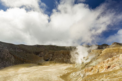 Scenic view of mountain range against cloudy sky