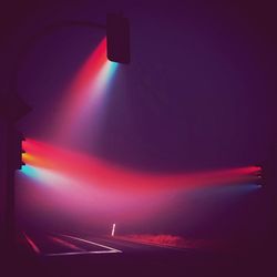 Illuminated light bulb against sky at night