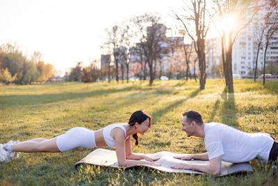 Rear view of woman sitting on field