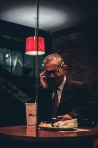 Reflection of man in glass on table