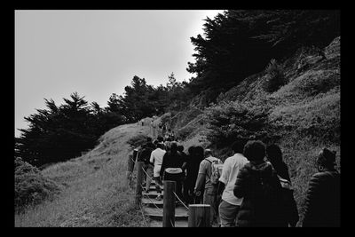 Rear view of people walking on the road