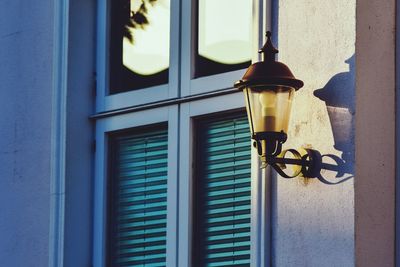 Close-up of illuminated lamp against building