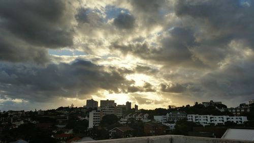 Buildings against cloudy sky at sunset