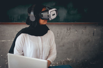 Female teacher using virtual reality simulator in classroom