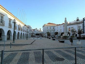 Street amidst buildings in town against clear blue sky