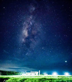 Scenic view of illuminated field against sky at night