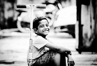 Portrait of smiling boy sitting outdoors