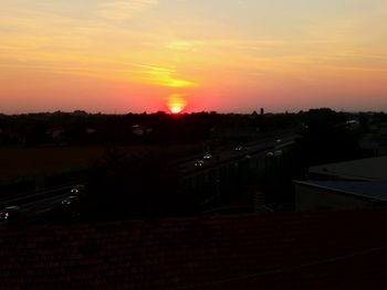 Silhouette city against sky during sunset