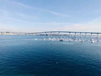 Bridge over sea against blue sky