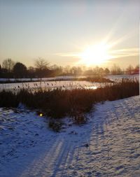 Scenic view of frozen lake against sky during sunset