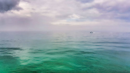 Scenic view of calm sea against cloudy sky