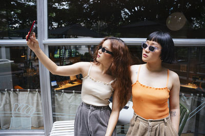 Young woman in sunglasses standing outdoors