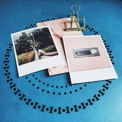 Close-up of postcards with binder clip on table