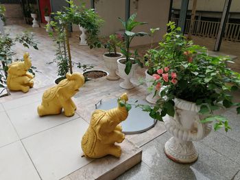High angle view of statue by potted plants on table