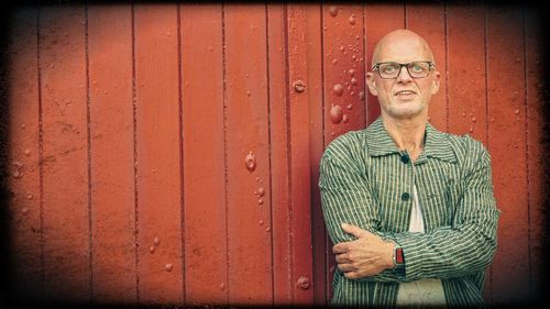 Portrait of smiling man standing against wall