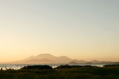 Scenic view of lake against clear sky during sunset