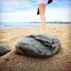 Low section of woman standing on sand at beach